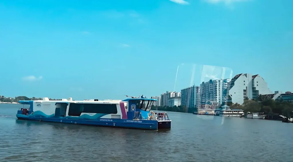 a wide view of a Kochi Water Metro vessel approaching Hight Court station